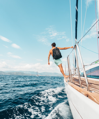 man-wearing-backpack-standing-on-side-of-boat-during-daytime-1223648